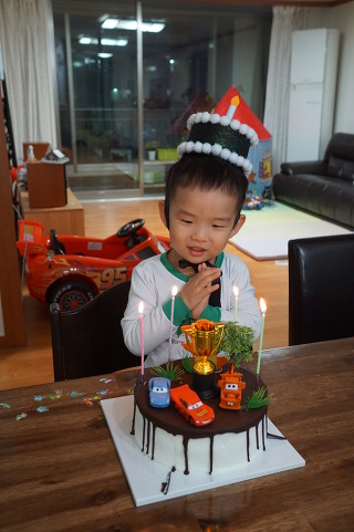 생일 파티로 케익을 바라보는 아들 서율이
