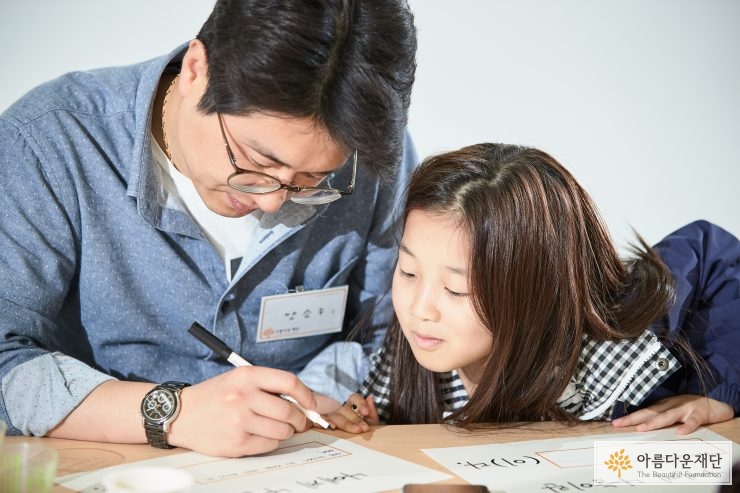 아빠와 딸이 나눔한마디를 고민하며 작성하는 모습
