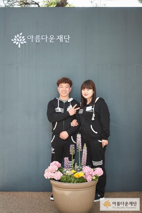 결혼기념기부를 한 부부가 재단 앞에서 나란히 서 있는 모습
