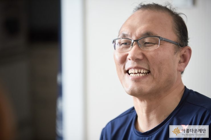 기부자가 활짝 웃고 있는 옆모습