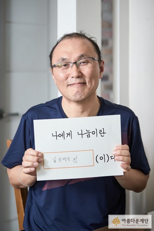 기부자가 자신에게 있어 나눔한마디를 작성해서는, 들고 찍은 모습.