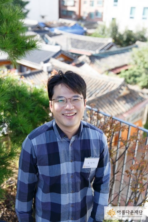 옥상에서 환하게 웃고 있는 기부자 모습