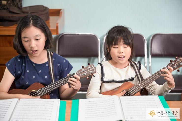 우쿨렐레를 연주하는 두 아이