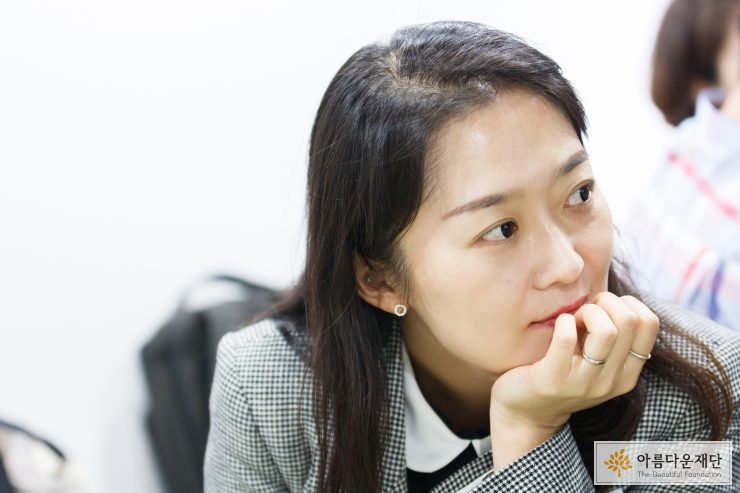 백정연 기부자가 손을 턱에 괴고 강연을 보고 있다.