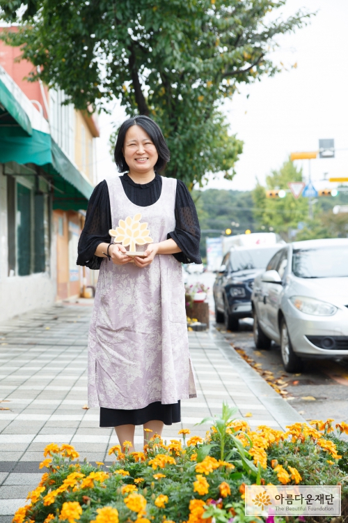 카페 앞 화단에서 활짝 웃고 있는 하희정 기부자