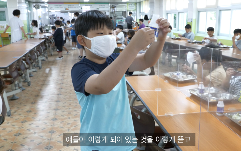 음료수 병 분리배출을 위해 친구들에게 분리수거 방법을 설명하고있다
