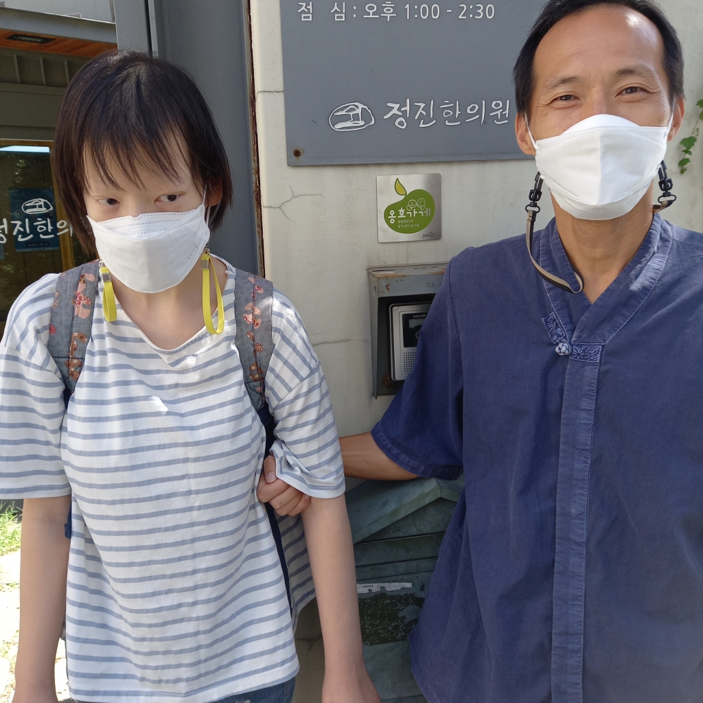 피아노님과 옹호가게 정진한의원 원장님이 옹호가게 앞에서 같이 카메라를 바라보고 있다.