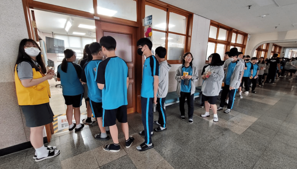 행사장에 들어가기 위해 줄서있는 청소년들