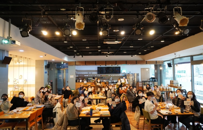 큰 홀에 청년활동가 30여명이 앞쪽을 향해 손을 흔들고 있다.