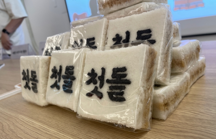 첫돌이라고 쓰인 백설기 떡이 책상 가운데 쌓여있다.