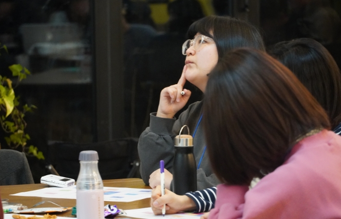 토리 활동가가 왼쪽을 향해 보고 앉아있다. 오른손으로 턱을 짚으며 고민하는 모습