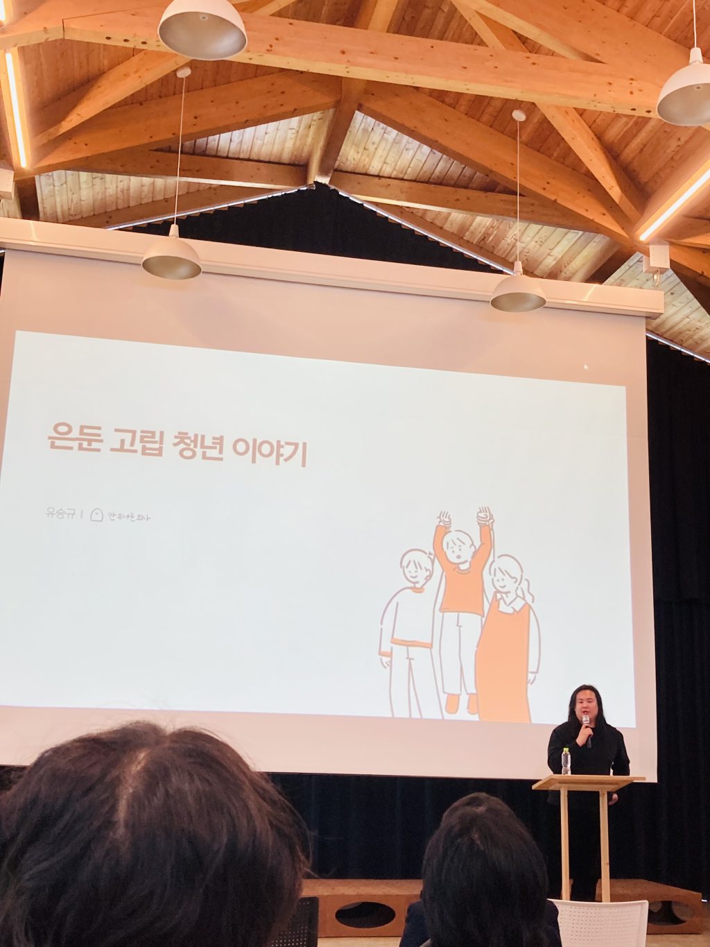 은둔 고립 청년이야기라고 써 있는 화면 앞에서 남성이 강연을 하고 있다. 