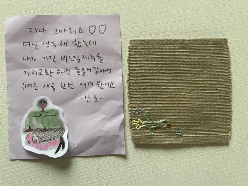 지나 고마워요. 며칠 생각해 봤는데 내가 가진 바느질 재주를 가치교환하면 좋을 거 같아서 귀연운 새를 한 번 새겨봤어요. 산호 라고 써 있는 쪽지와 천으로 된 컵 받침에 새가 수 놓아져 있다. 