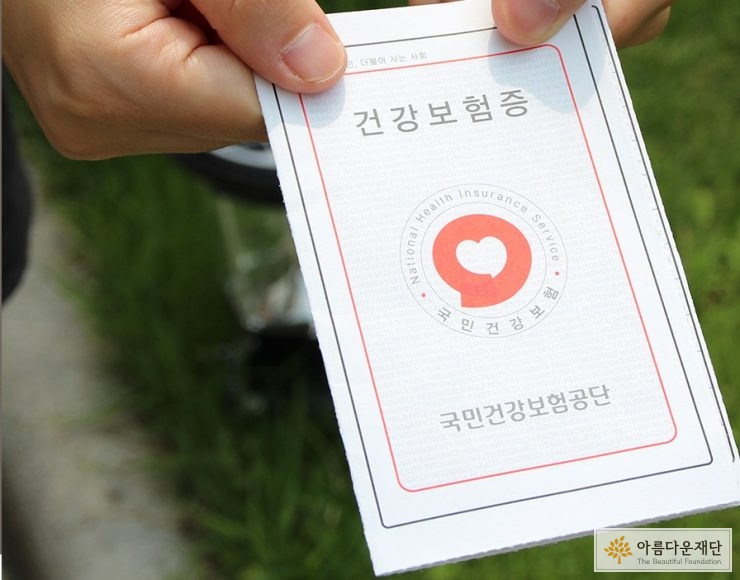 국민건강보험공단에서 지급하는 건강보험증을 들고 있는 모습