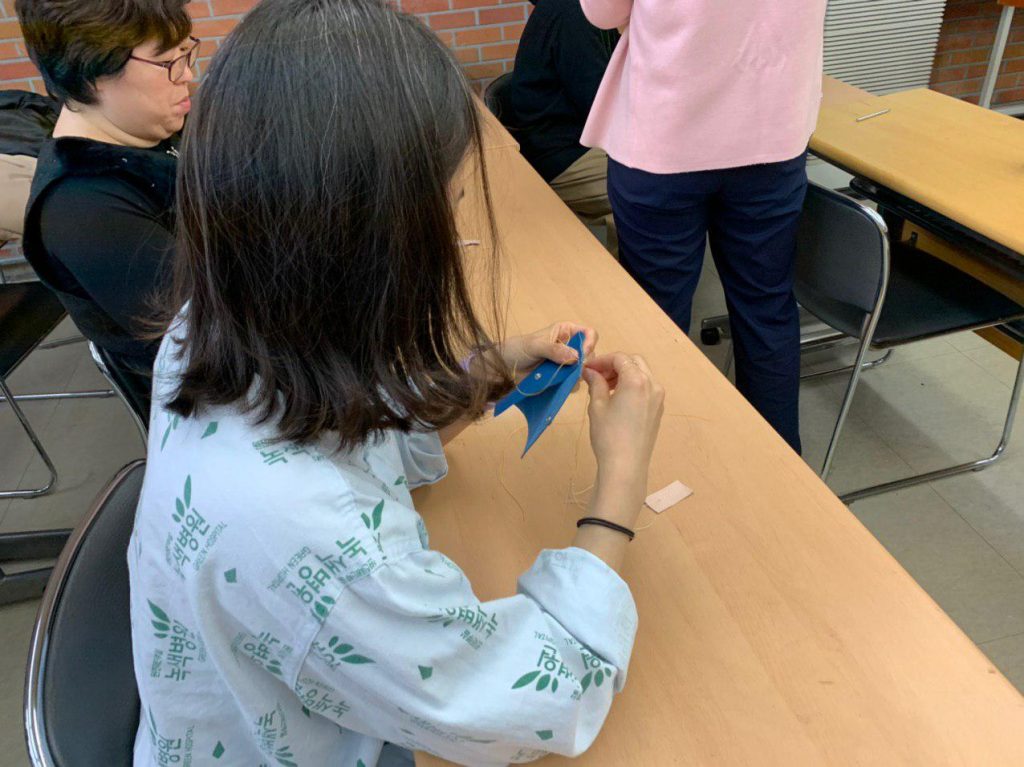 재능 기부로 가죽공예 수업을 하는 모습
