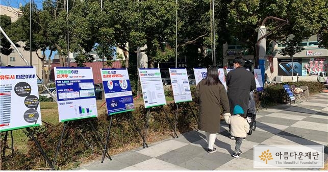 제주 드림타워의 문제를 알리는 보드 전시를 지나가는 시민이 살펴보고 있다.
