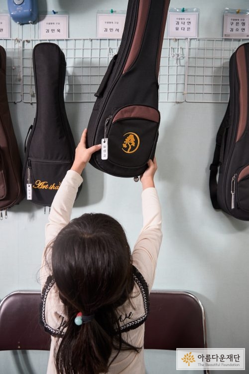 벽에걸린 우쿨렐레를 꺼내는 아이