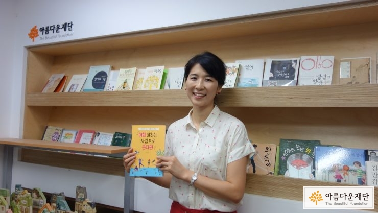 책을 들고 서 있는 류한경 작가님
