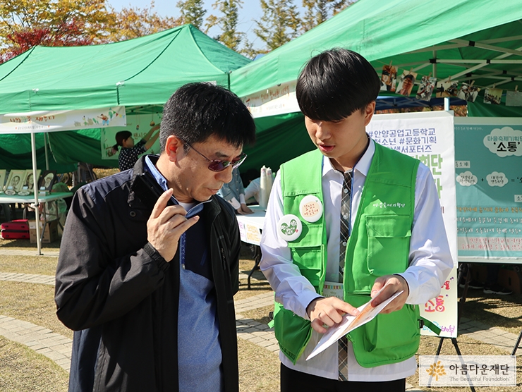 <마을축제기획단소통>의 멤버가 주민에게 마을축제를 설명하는 모습