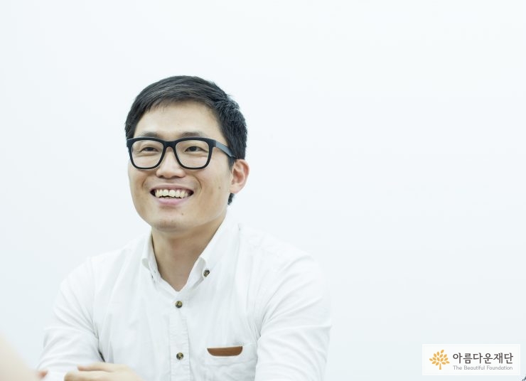 흰 셔츠를 입고 검은 뿔테 안경을 쓴 남자