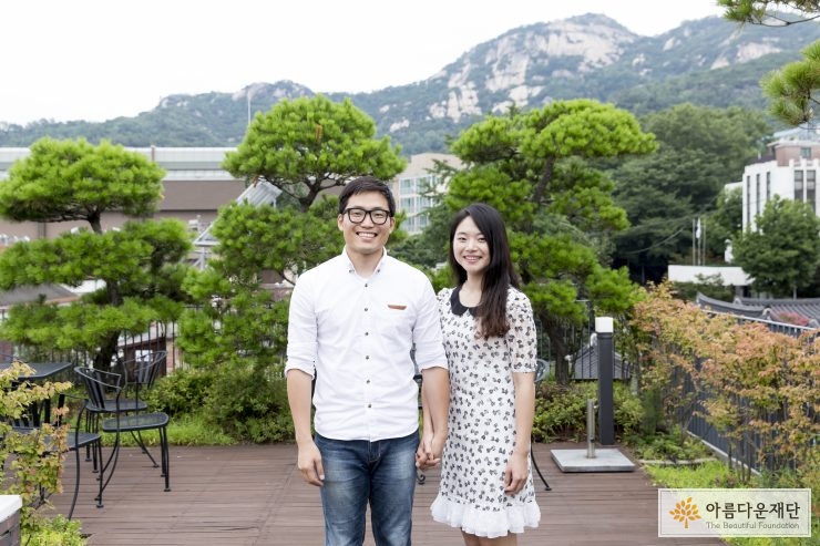 인왕산을 배경으로 나란히 손을 잡고 서있는 두사람 