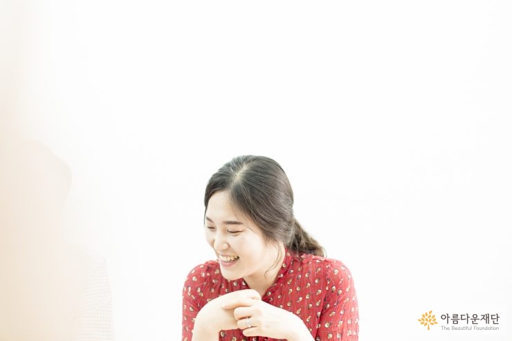 손을 모으고 환하게 웃고 있는 모습