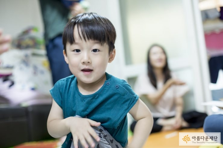 녹색 옷을 입고 앉아있는 아이