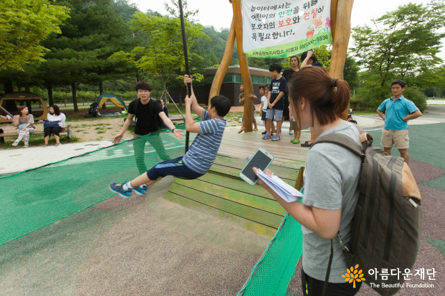 짚라인을 타고 내려오는 장애아동