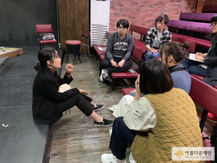 청년창작집단'ㅁ'과 청소년배분위원들이 무대 앞에서 마주앉아 이야기를 나누고 있다